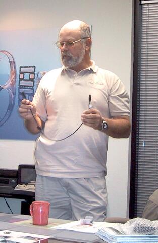 Person holding a black connector of about 2 feet in length.